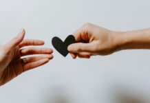 정신적 웰빙을 위한 긍정적인 습관 만들기 person reaching black heart cutout paper