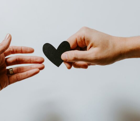 정신적 웰빙을 위한 긍정적인 습관 만들기 person reaching black heart cutout paper