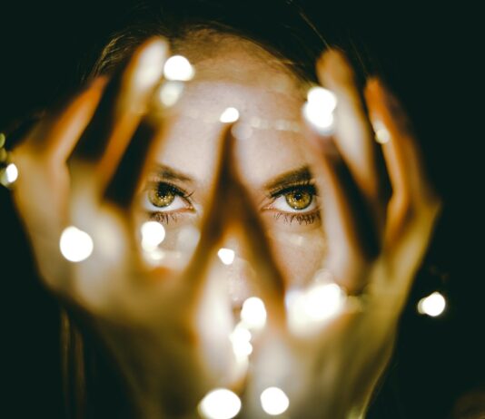 다크서클 예방법 woman holding string lights