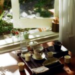 일상이 무거운 당신을 위한 만성피로 극복 트렌드와 실천법 Tea set arranged on a wooden tray by the window.