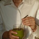 일상으로 스며든 웰니스 문화, 나만의 건강 루틴 만들기 person in white button up shirt holding clear drinking glass with green liquid