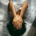 “일상 속 스트레스, 작지만 꾸준한 실천으로 다스린다” a woman holds her hands over her face