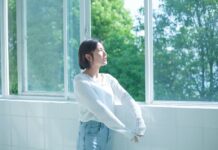 정신건강, ‘작은 습관’에서 시작한다… 일상에서 실천하는 마음 건강법 woman in white long sleeve shirt and blue denim jeans standing by the window