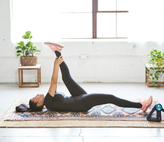 바쁜 일상 속 ‘웰니스 회복’, 나만의 작은 휴식이 건강을 지킨다 woman in black tank top and black leggings lying on black and white floral area rug